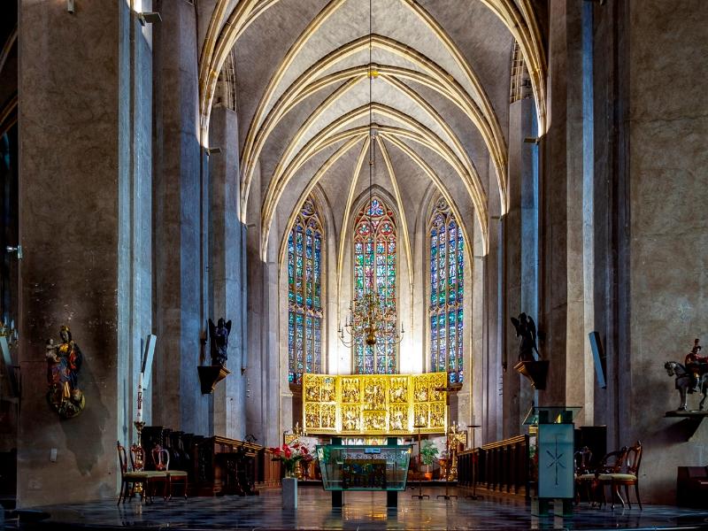 Sfeervol gotisch interieur van de Sint-Martinuskerk in Venlo met glas-in-loodramen en gouden altaarstuk