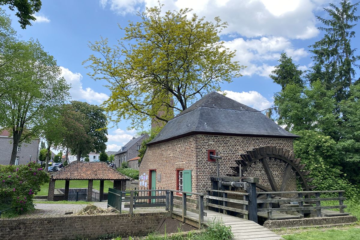 Historische watermolen met waterrad in een schilderachtig Limburgs dorp langs de Maasroute