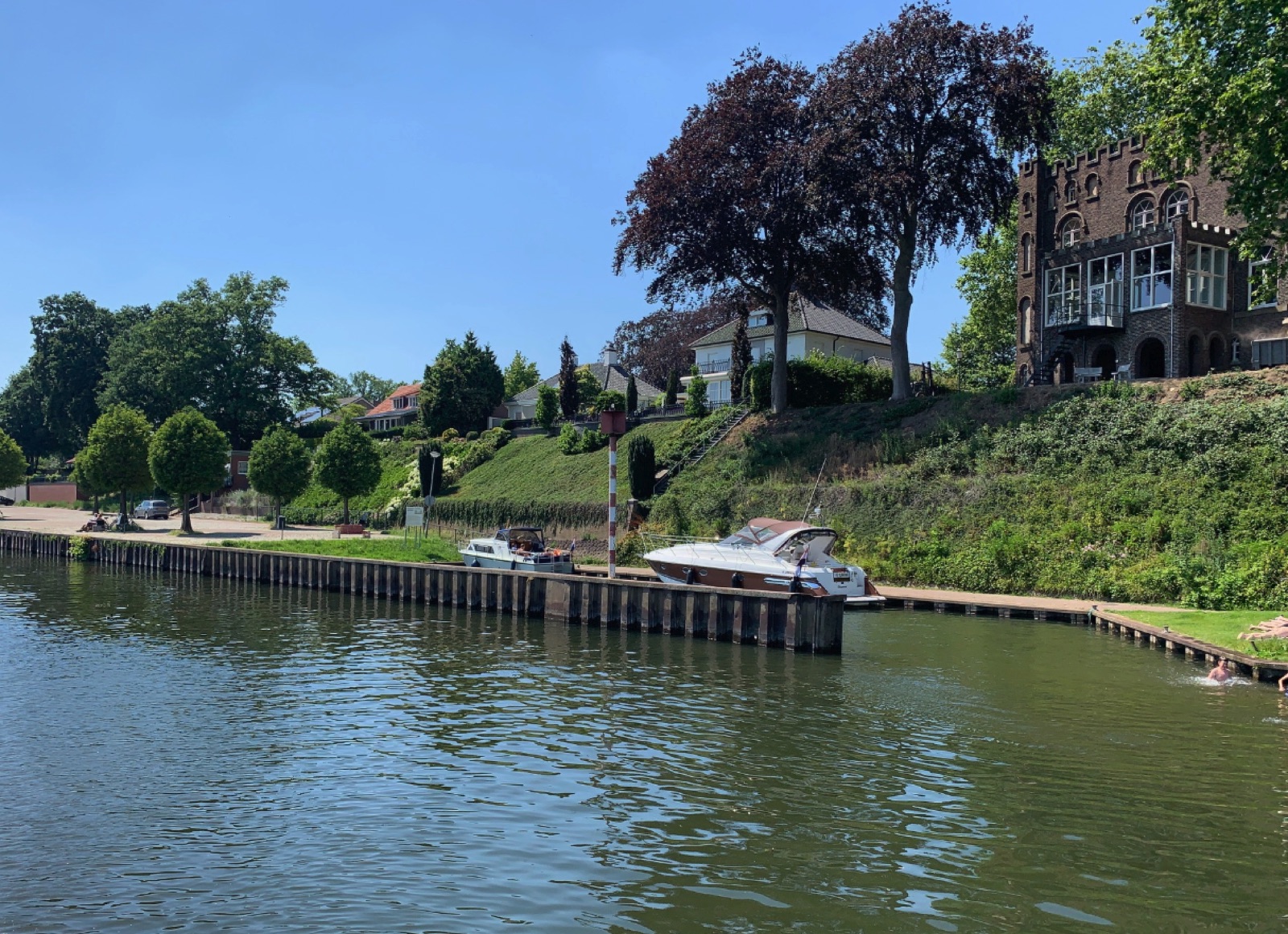 De Maas bij Kessel met jachthaven en statige villa's op de Maasroute in Noord-Limburg