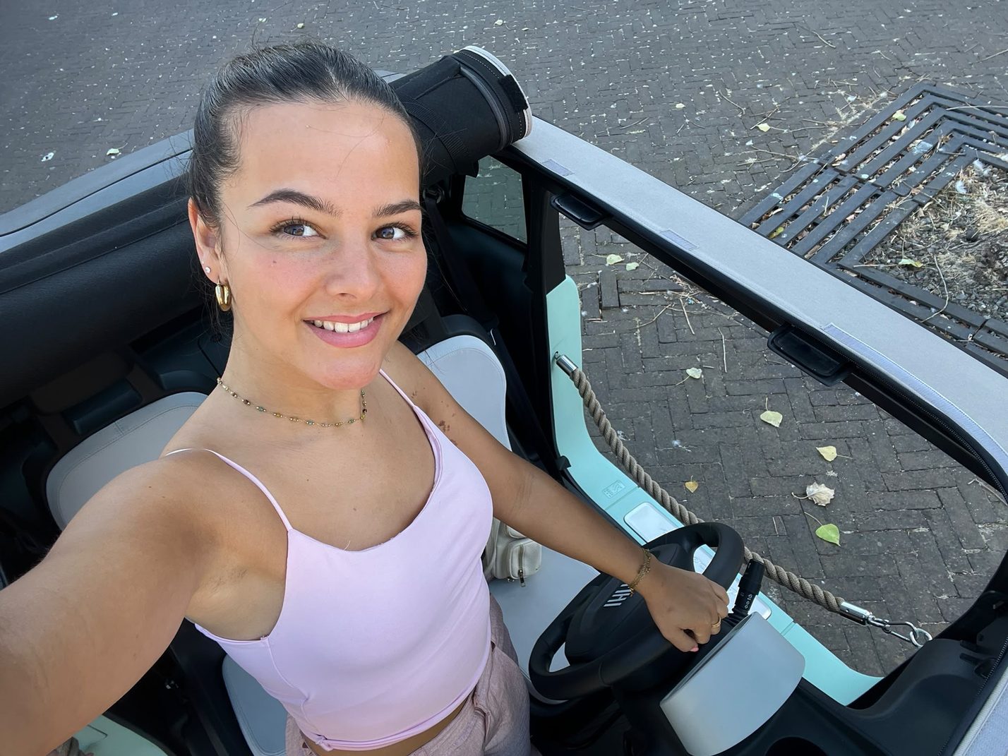 Lachende bestuurster in de open Fiat Topolino tijdens een dagje uit